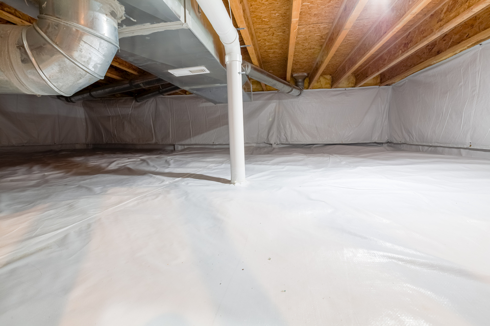 A clean, encapsulated crawl space with white plastic lining on the floor and walls, exposed wood beams on the ceiling, and visible ducts and pipes.